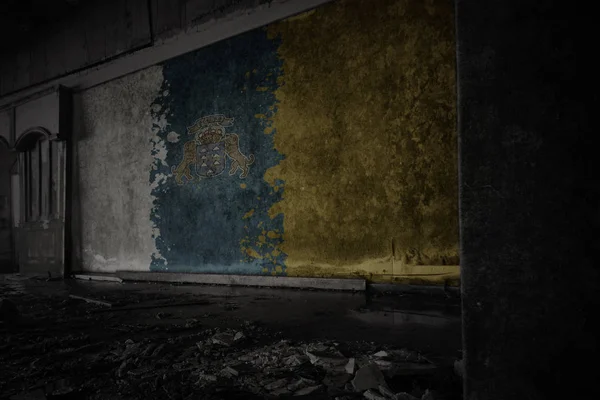 在一座废弃的废弃房屋中，在肮脏的旧墙上画着金丝雀岛的旗帜. — 图库照片