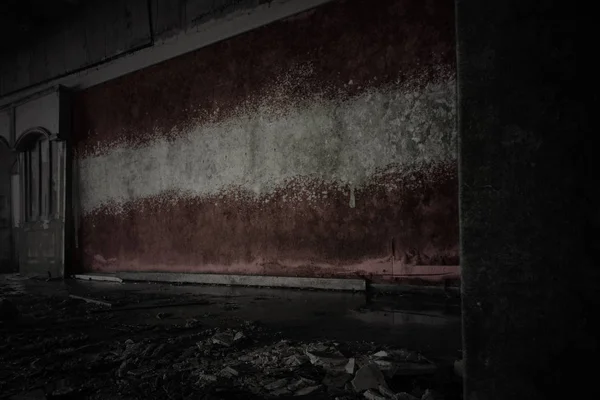 Bandeira pintada de latvia na parede velha suja em uma casa arruinada abandonada . — Fotografia de Stock