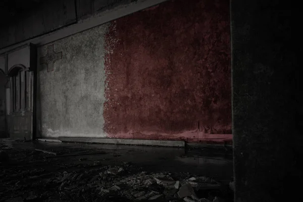 在一座废弃的废弃房屋的肮脏的旧墙上画着马耳他的旗帜. — 图库照片