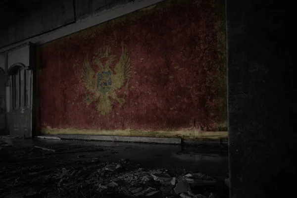 Bandera pintada de montenegro en la pared vieja sucia en una casa arruinada abandonada . —  Fotos de Stock