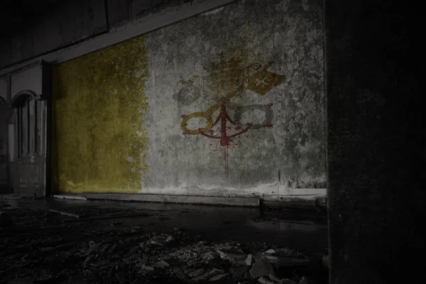 Gemalte Fahne der vatikanischen Stadt an der schmutzigen alten Mauer eines verlassenen, zerstörten Hauses. — Stockfoto