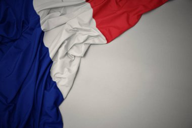 gri bir arka planda Fransa 'nın Ulusal bayrağı sallıyor.