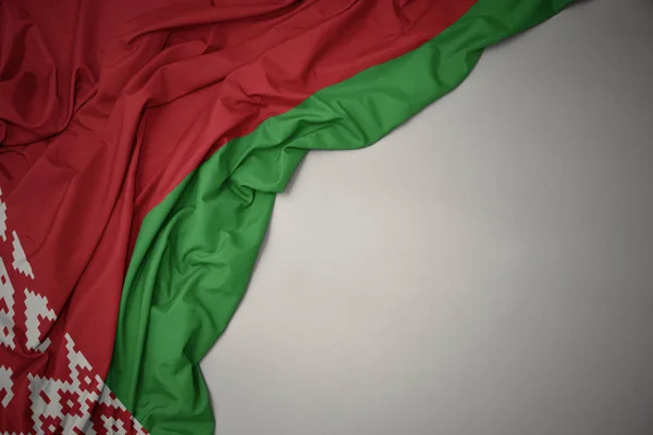 Wuivende nationale vlag van Wit-Rusland op een grijze achtergrond. — Stockfoto