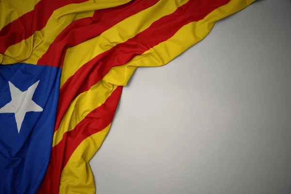 Sventolando bandiera nazionale della Catalogna su sfondo grigio . — Foto Stock