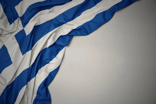 Ondeando bandera nacional de Grecia sobre un fondo gris . — Foto de Stock