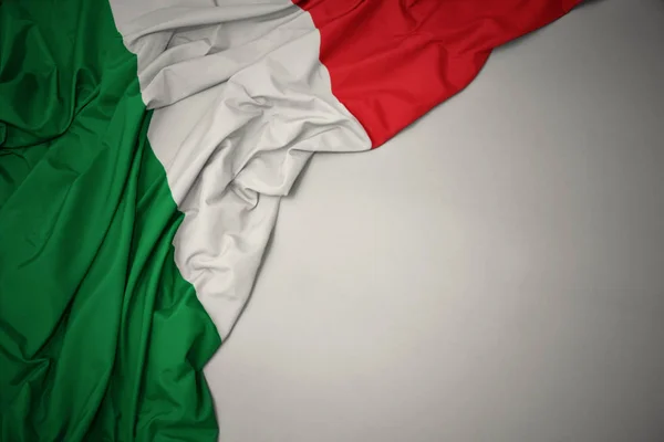 Zwaaiende nationale vlag van Italië op een grijze achtergrond. — Stockfoto