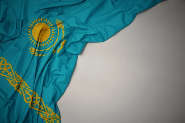 waving national flag of kazakhstan on a gray background.