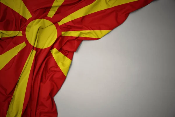 Acenando bandeira nacional da macedônia em um fundo cinza . — Fotografia de Stock