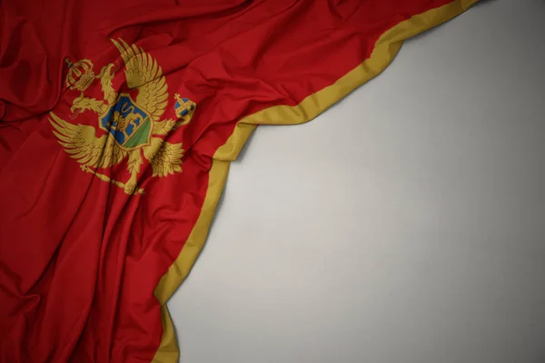 Ondeando bandera nacional de montenegro sobre un fondo gris . — Foto de Stock