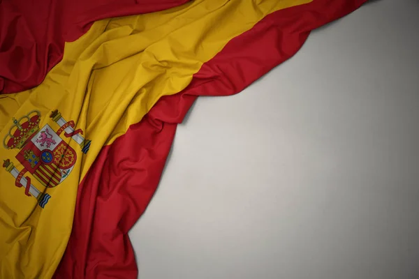 Falowanie flagi narodowej Hiszpanii na szarym tle. — Zdjęcie stockowe
