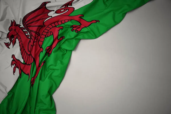 Wuivende nationale vlag van Wales op een grijze achtergrond. — Stockfoto