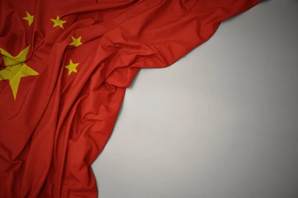 Mávající národní vlajku Číny na šedém pozadí. — Stock fotografie