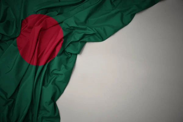 Falowanie flagi narodowej Bangladeszu na szarym tle. — Zdjęcie stockowe