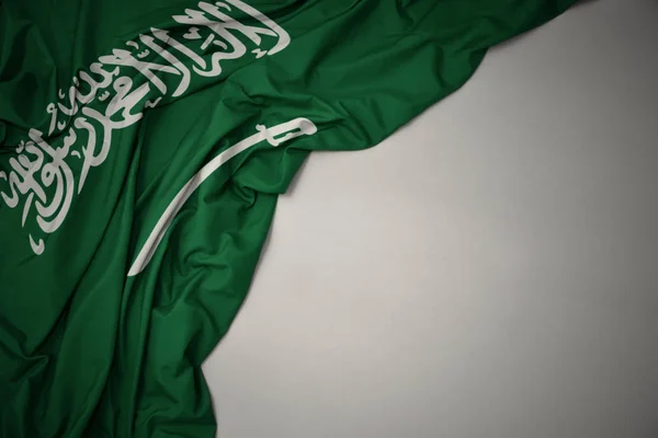 Ondeando la bandera nacional de Arabia Saudí sobre un fondo gris . —  Fotos de Stock