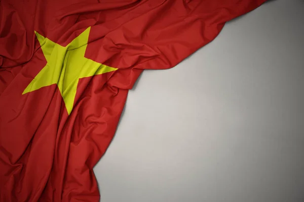 灰色の背景にベトナムの国旗を振る. — ストック写真