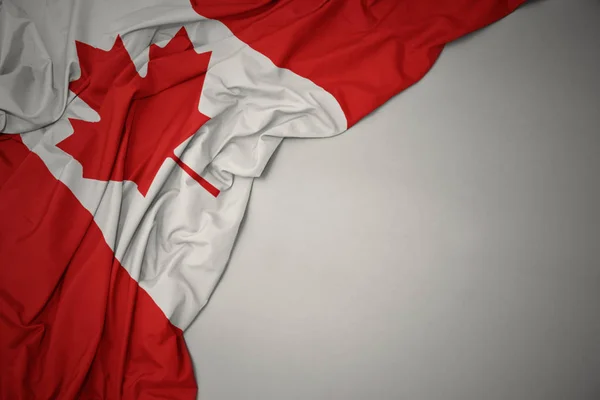 Falowanie narodowej flagi Kanady na szarym tle. — Zdjęcie stockowe
