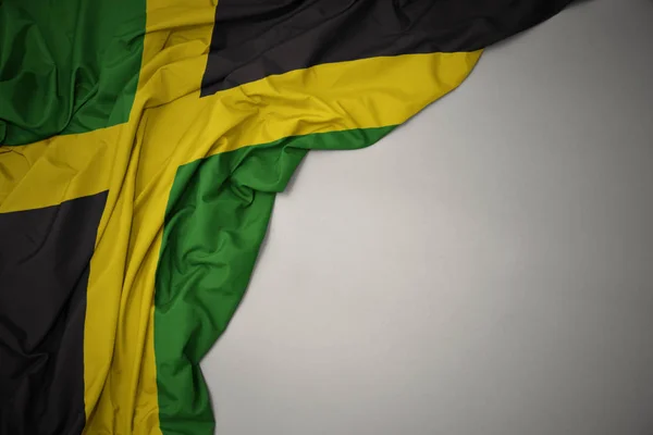 Waving national flag of jamaica on a gray background. — Stock Photo, Image