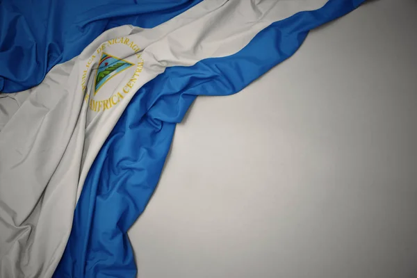 Falowanie flagi narodowej Nikaragui na szarym tle. — Zdjęcie stockowe