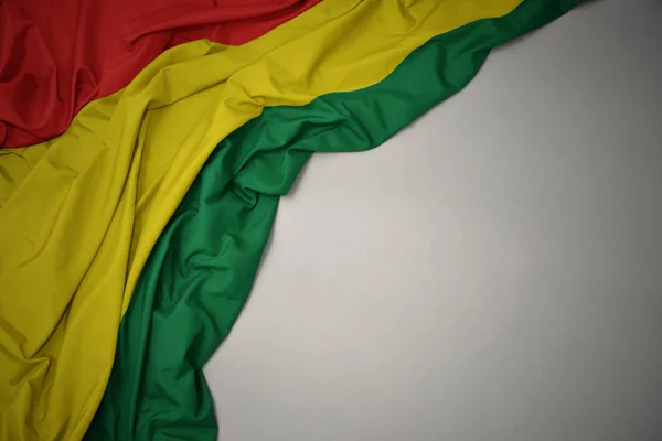 Ondeando la bandera nacional de Bolivia sobre un fondo gris . — Foto de Stock