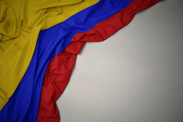 Zwaaiende nationale vlag van Colombia op een grijze achtergrond. — Stockfoto