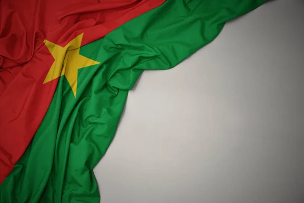 Waving national flag of burkina faso on a gray background. — Stock Photo, Image