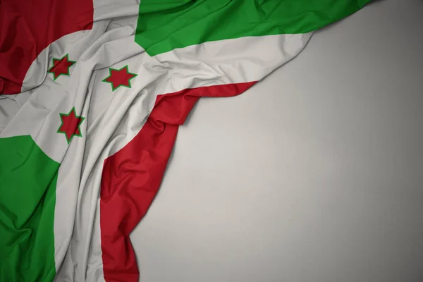 Falowanie flagi narodowej Burundi na szarym tle. — Zdjęcie stockowe