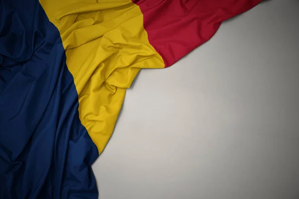 Ondeando bandera nacional de Chad sobre un fondo gris . —  Fotos de Stock