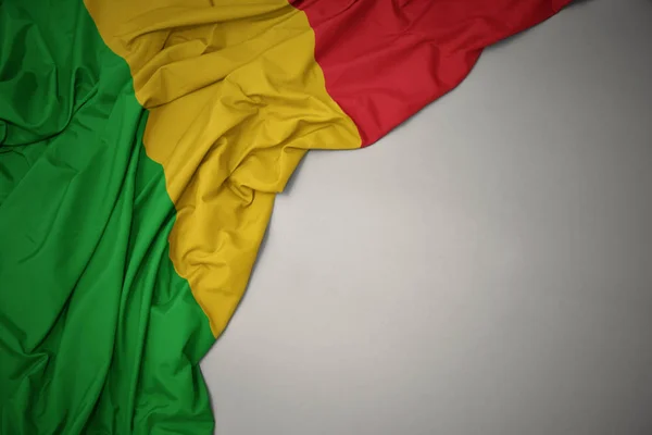 waving national flag of mali on a gray background.