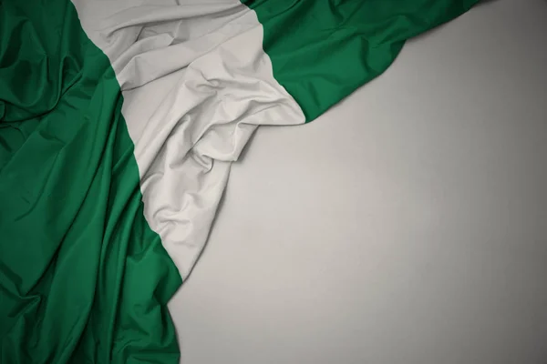 Ondeando bandera nacional de nigeria sobre un fondo gris . — Foto de Stock