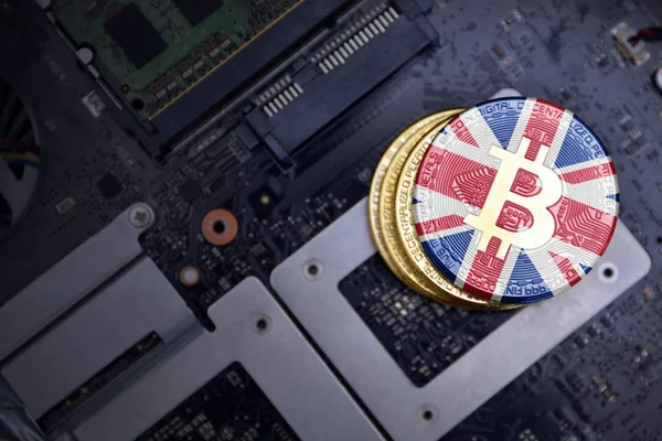 bir bilgisayar elektronik devre kartı üzerinde büyük Britanya bayrağı ile altın bitcoins. bitcoin madencilik kavramı.