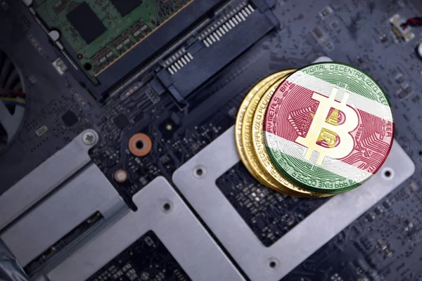 Bitcoins dorados con bandera de surinam en una placa de circuito electrónico de computadora. concepto de minería bitcoin . —  Fotos de Stock