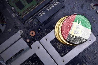 bir bilgisayar elektronik devre kartı üzerinde birleşik arap emirlikleri bayrağı ile altın bitcoins. bitcoin madencilik kavramı.