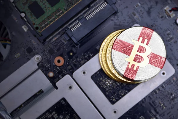 Bitcoins dorados con bandera de Inglaterra en una placa de circuito electrónico de computadora. concepto de minería bitcoin . —  Fotos de Stock