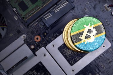bir bilgisayar elektronik devre kartı üzerinde tanzanya bayrağı ile altın bitcoins. bitcoin madencilik kavramı.