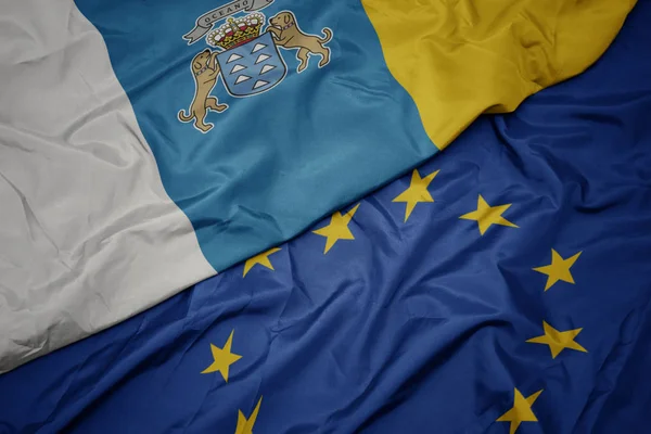 Ondeando colorida bandera de la unión europea y bandera de las islas canarias . —  Fotos de Stock