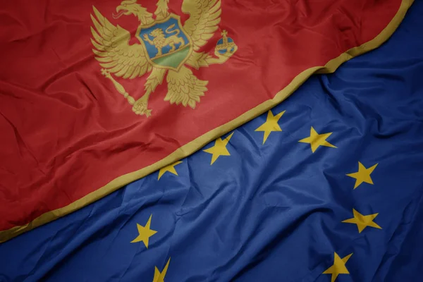 Agitant drapeau coloré de l'union européenne et drapeau national de montenegro . — Photo