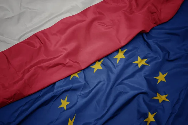 Falujące kolorowe flagi Unii Europejskiej i flagi narodowej Polski. — Zdjęcie stockowe