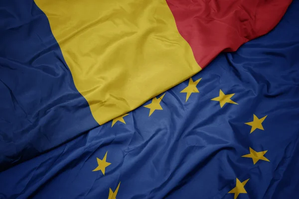 挥舞着五颜六色的欧盟国旗和罗马尼亚国旗. — 图库照片