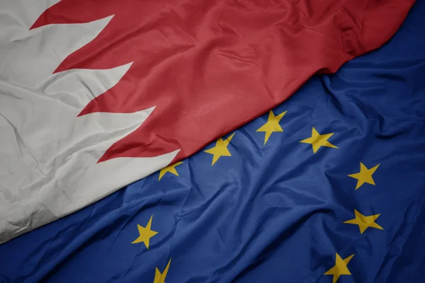 waving colorful flag of european union and flag of bahrain.