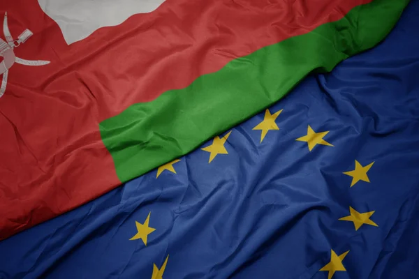 Waving colorful flag of european union and flag of oman. — Stock Photo, Image