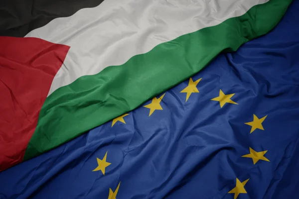 Waving colorful flag of european union and flag of palestine. — Stock Photo, Image