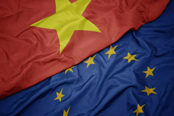 Махаючи барвистим прапором європейського союзу та прапором В'єтнаму . — стокове фото