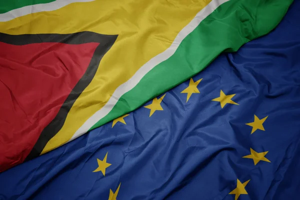Waving colorful flag of european union and flag of guyana. — Stock Photo, Image