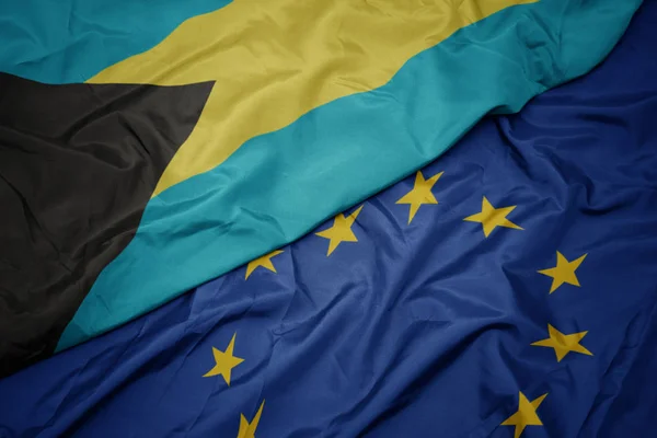 Agitant drapeau coloré de l'union européenne et drapeau des bahamas . — Photo