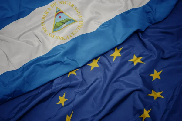 Waving colorful flag of european union and flag of nicaragua. — Stock Photo, Image