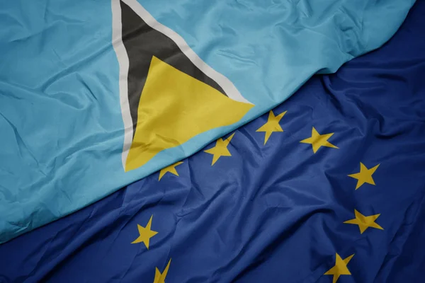 Ondeando colorida bandera de la unión europea y bandera de santa lucia . — Foto de Stock