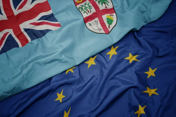 挥舞着五颜六色的欧盟旗帜和斐济国旗. — 图库照片