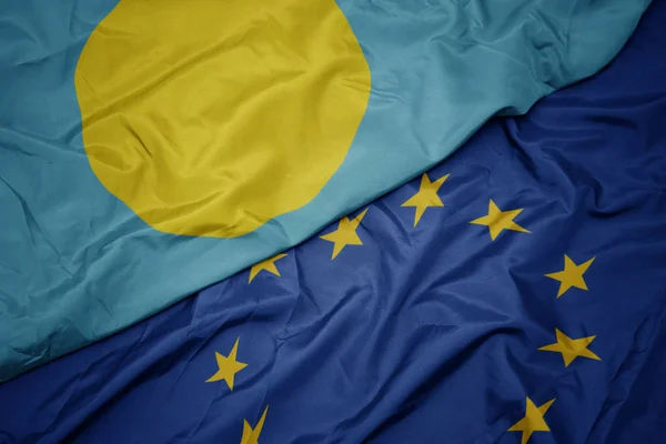 Waving colorful flag of european union and flag of Palau . — Stock Photo, Image