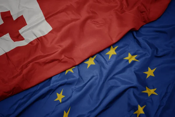 Agitant le drapeau coloré de l'union européenne et le drapeau des Tonga . — Photo