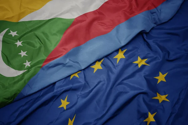 Avrupa birliği ve komor bayrağı renkli bayrak sallayarak. — Stok fotoğraf